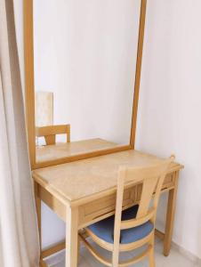 mesa de madera con espejo y silla en Alykes Family Resort en Lefkímmi