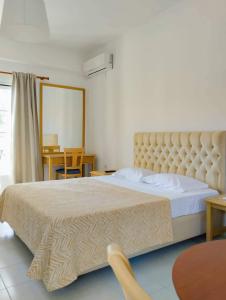 una camera da letto con un grande letto con una grande testiera di Alykes Family Resort a Lefkimmi