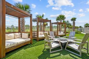 a patio with two gazebos and chairs and a table at Calypso Resort Tower 3 Rentals in Panama City Beach