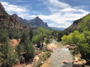 einen Fluss in einem Canyon mit Bäumen und Bergen in der Unterkunft Cedar Lodge in Cedar City