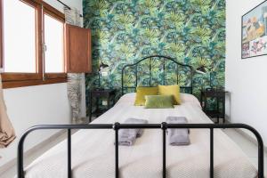 a bedroom with a bed with a blue and green wallpaper at El Rincón de los Artistas in Las Palmas de Gran Canaria