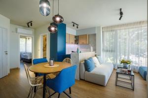 a kitchen and living room with a table and blue chairs at Kraimorie Park in Burgas