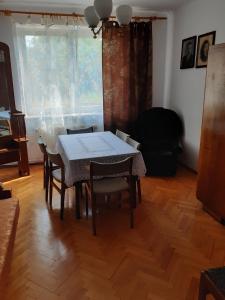 uma sala de jantar com uma mesa e cadeiras e uma janela em Zwolaki em Ulanów