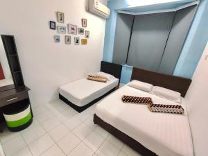 Habitación con 2 camas y TV. en Kampar Sakura 2 Landed, en Kampar