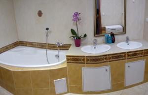 uma casa de banho com 2 lavatórios e uma banheira em Alžbetina- Luxury Large Apartment 21 em Košice