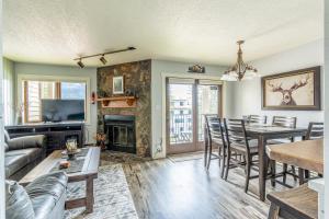 een woonkamer met een tafel en een open haard bij Altitude Adjustment in Whitefish