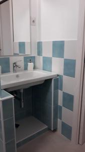 a bathroom with a sink and blue and white tiles at mare blu in Gizzeria