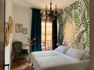 a bedroom with a bed and a chandelier at La Fabbrica dell'Oro in Asti