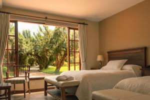 um quarto com uma cama e uma grande janela em Hotel Hacienda Abraspungo em Riobamba