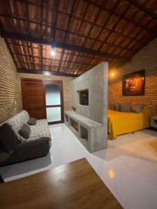 uma sala de estar com um sofá amarelo e uma lareira em Recanto da Crôa em Barra de Santo Antônio