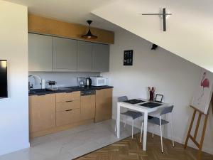 a kitchen with a table and a counter top at Kawalerka premium B 30m2 - po remoncie - nowa! in Warsaw