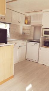 a kitchen with white cabinets and white appliances at 2 chambres à 15 mn de la mer en pleine nature Jacuzzi dispo du 01 avril au 15 octobre in Anneville-sur-Scie