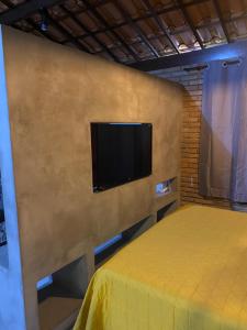a bedroom with a bed and a flat screen tv at Recanto da Crôa in Barra de Santo Antônio