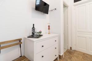 a white dresser with a tv on a wall at El Rincón de los Artistas in Las Palmas de Gran Canaria