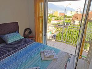 1 dormitorio con cama y vistas a un balcón en Bella Apartments, en Bijela