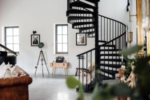 a living room with a black spiral staircase at Loftlakásom**** in Veszprém