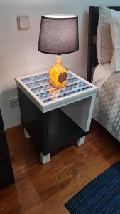 a lamp on a table next to a bed at Maligueira Apartment in Leiria +23 photos