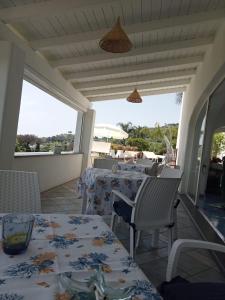een eetkamer met tafels en stoelen op een patio bij Relais Villa Ettore in Ischia