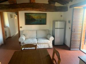 a living room with a white couch and a refrigerator at La Casa Colonica in Tuoro sul Trasimeno