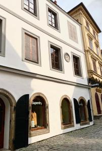 a white building with arched windows on a street at Belcanto Apartments in Český Krumlov
