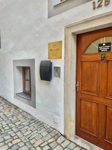 een houten deur aan de zijkant van een gebouw bij Belcanto Apartments in Český Krumlov