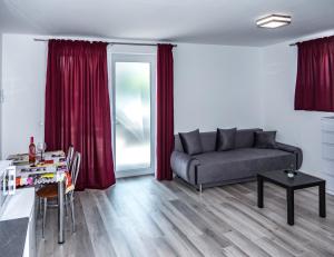 a living room with a couch and a table at FeDa Apartmanház in Balatonboglár