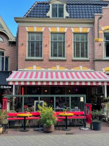 a restaurant with red tables in front of a building at Comfortable Room in Alkmaar