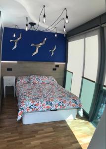 - une chambre avec un lit avec des oiseaux sur le mur dans l'établissement Apartamento Rosario 2, à Vigo