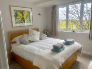 Un dormitorio con dos camas con toallas encima. en 2 Bedroom cottage sleeps 4 with Hot-tub, & shared Pool use, en Sennen 26 fotos más