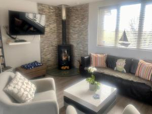 a living room with a couch and a fireplace at 2 Bedroom cottage sleeps 4 with Hot-tub, & shared Pool use in Sennen