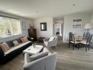 a living room with a couch and chairs and a table at 2 Bedroom cottage sleeps 4 with Hot-tub, & shared Pool use in Sennen