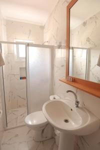 a bathroom with a sink and a toilet and a mirror at Ciftlik Hotel in Çeşme +111 photos