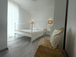 a white bedroom with a crib and a chair at Vila Regina Apartment Paloma with Swimming Pool in Jezera +132 photos