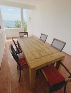 a wooden table and chairs in a room with a window at Apartments Veni Up in Starigrad