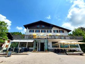 a building with chairs and umbrellas in front of it at Affittacamere Al Canyon PUB BIRRERIA in Fondo