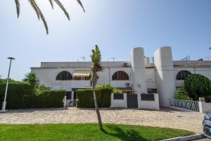 a palm tree in front of a building at Casas Blancas Parque Montroig in Miami Platja