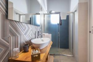 uma casa de banho com um lavatório e uma cabina de duche em vidro. em B&B Villa Massimo em Porto Cesareo