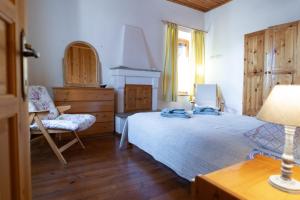 a bedroom with a bed and a desk and a chair at Stone House in Lafkos Pelion in Lafkos