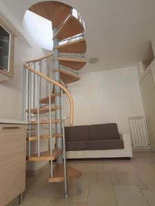 una scala a chiocciola in un soggiorno con divano di Appartamento estivo in centro città a San Benedetto del Tronto