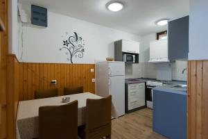 a kitchen with a table and a white refrigerator at Guesthouse Pavla in Goveđari