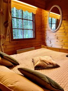 Schlafzimmer mit einem Bett mit einem Spiegel und einem Fenster in der Unterkunft Villa Talvitahko 5 in Tahkovuori