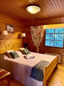 ein Schlafzimmer mit einem großen Bett in einer Hütte in der Unterkunft Villa Talvitahko 5 in Tahkovuori