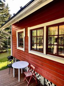a wooden deck with a table and chairs on it at Villa Talvitahko 5 in Tahkovuori