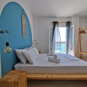 1 dormitorio con 1 cama grande y pared azul en KR Apartments en Aliki