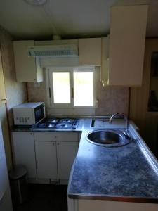a kitchen with a sink and a microwave at Bungalow in Laredo