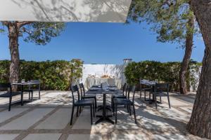 a table and chairs on a patio with trees at B&B Villa Massimo in Porto Cesareo
