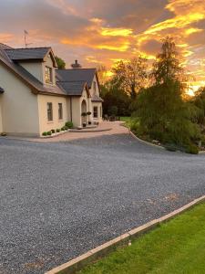 a house on a road with a sunset in the background at Corness House B&B in Monaghan