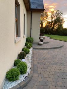 a house with a brick walkway next to a building at Corness House B&B in Monaghan