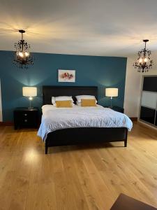 a bedroom with a bed with two lamps and blue walls at Corness House B&B in Monaghan