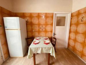 a small kitchen with a table and a refrigerator at Beach House in Lefkimmi